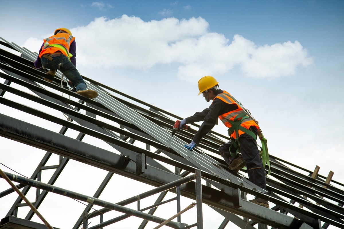 obreros trabajando en construccion de tejado